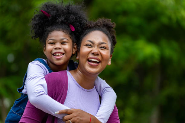 istock African American mother is playing piggyback riding with her young daughter while having a summer picnic in the public park for wellbeing and happiness 1828122933