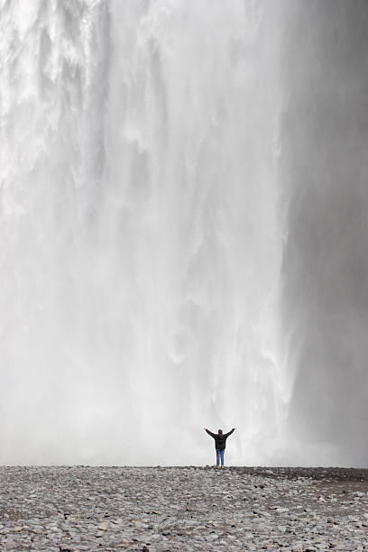istock Person With Arms in Air by Huge Waterfall 182812324