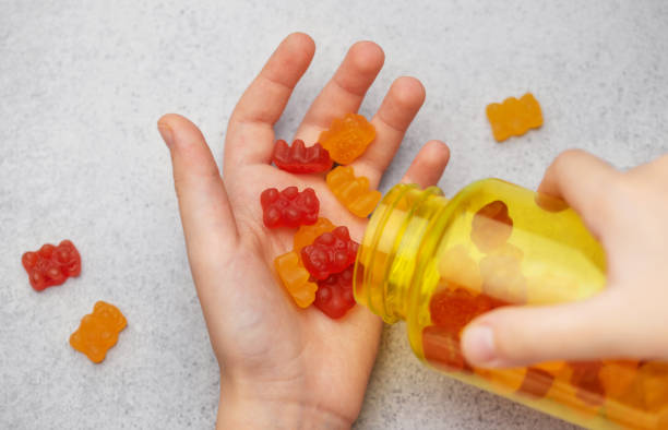 istock A girl holds a gummy bear vitamines in her hands 1828124561