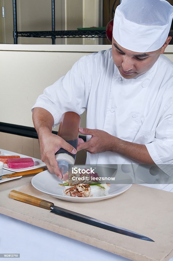 Lo Chef prepara un piatto a base di pesce crudo artistico - Foto stock royalty-free di Adulto