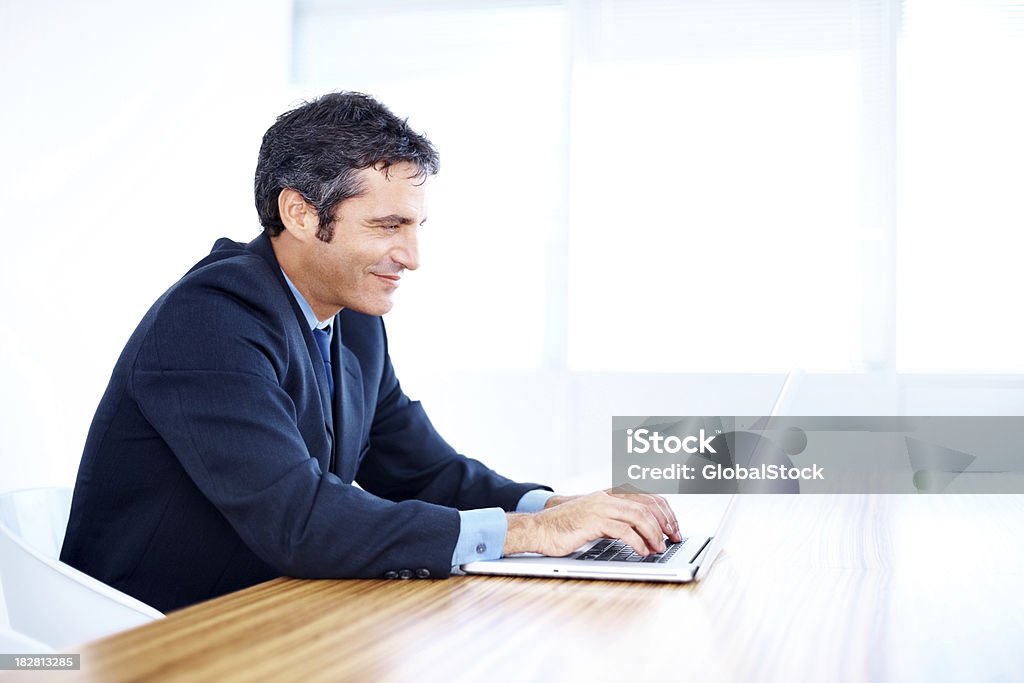 笑顔の中年ビジネスマン、ノートパソコンでの作業 - 1人のロイヤリティフリーストックフォト