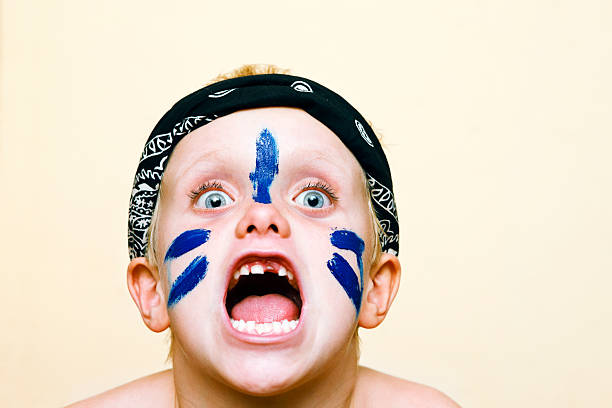 Little boy in face paint yells a battle cry