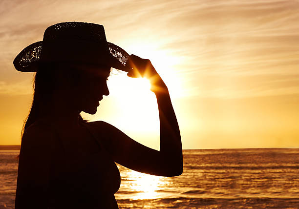 istock Silhouette of a lady wearing beach hat at dusk 182814352