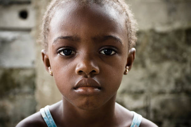 Close-up of innocent African girl with sad expression An African girl looking seriously at the camera. poverty child ethnic indigenous culture stock pictures, royalty-free photos & images