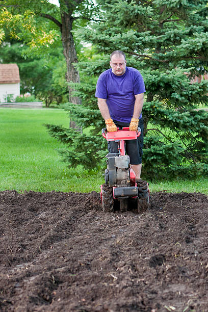 istock man in garden with roto tiller 182815354