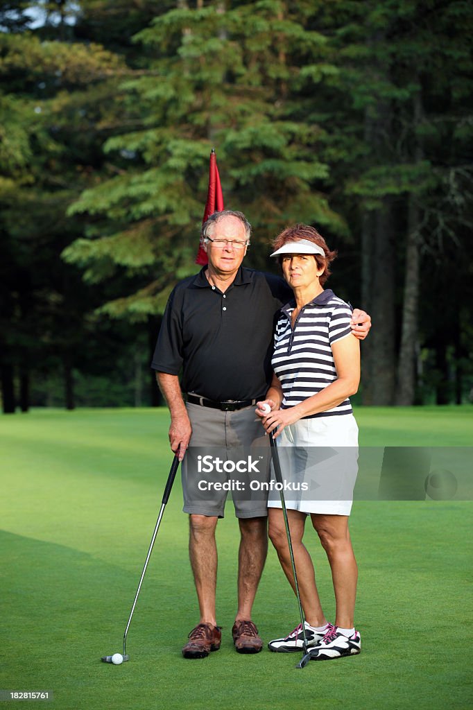 Heterossexuais, casal sênior jogando golfe no campo de golfe - Foto de stock de 55-59 anos royalty-free