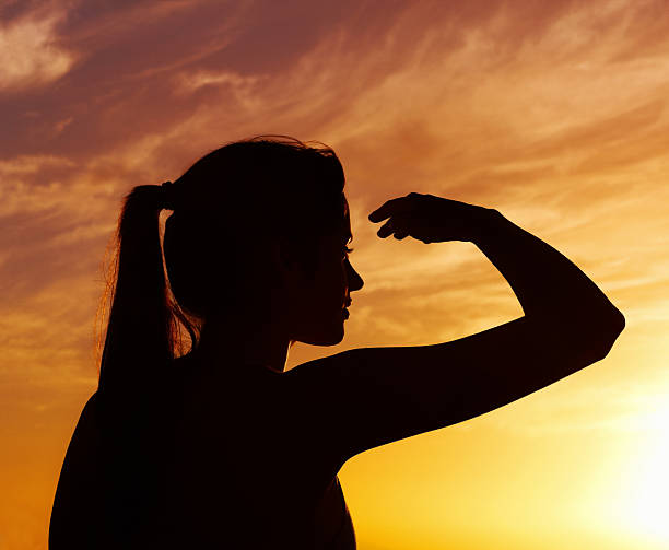istock Silhouette lady with shielding eyes on a beach 182815783