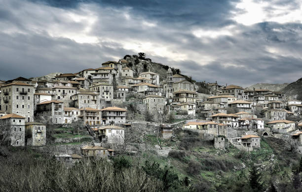 mountain village view of a stone building on mountain village named Valtesiniko under a heavy cloudy sky. Arcadia- Greece arachova greece stock pictures, royalty-free photos & images