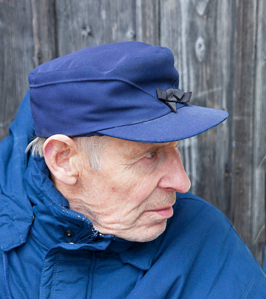 istock Old man in blue cap and jacket looking far away. 182816022