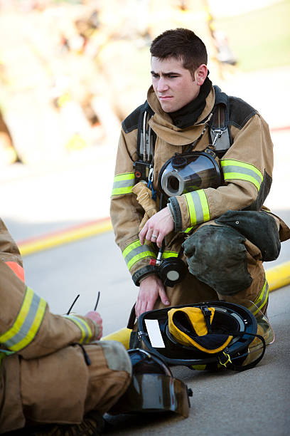 istock Young Firefighter Kneeling Down With Fire Fighter Equipment On 182816142