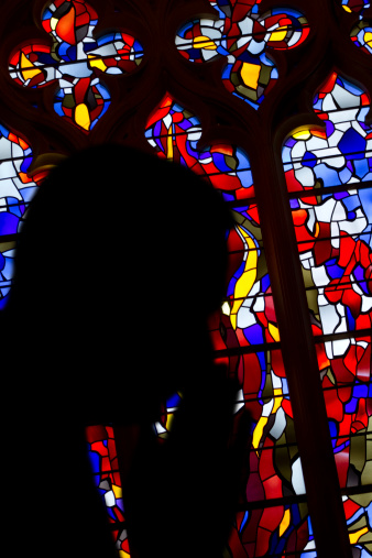 Silhouette of a man praying in church.  Shot with a Canon 7D in Washington DC.