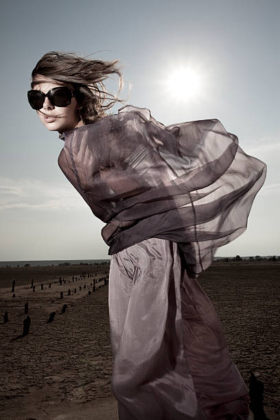 Caucasian woman in a black dress descends from a mountain in the desert