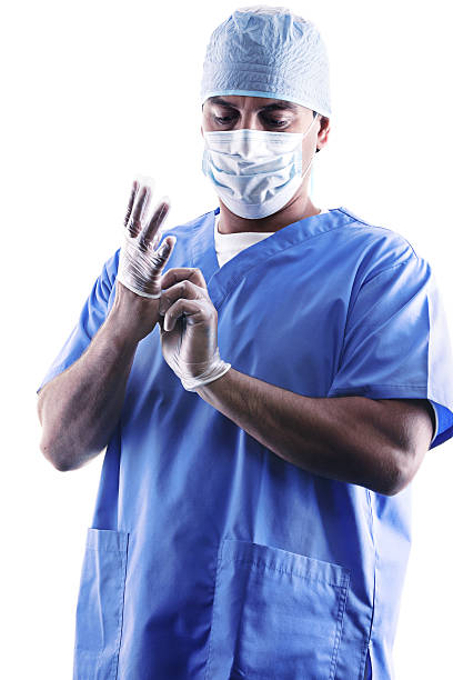 Tired surgeon removing gloves after surgery stock photo