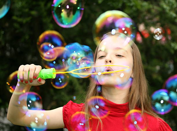 istock Gorgeous young girl blowing soap bubbles. 182817064