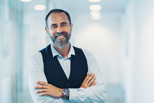 Smiling mature businessman standing in the office