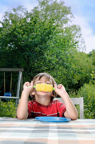 istock Child eating a corn cob outside in the summer 182817191