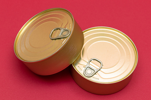 Unopened Tin Cans with Blank Edges on Red Background