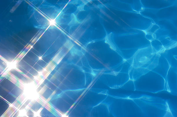 Deep blue pool water with bright lens flares in the corner stock photo