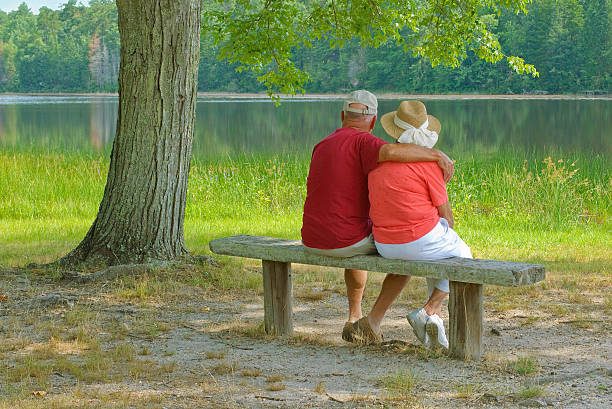 старший пара расслабляющий - senior women senior adult bench flower стоковые фото и изображения