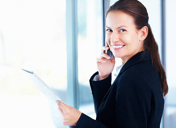 istock Smiling mid adult business woman using cellphone while at work 182818759