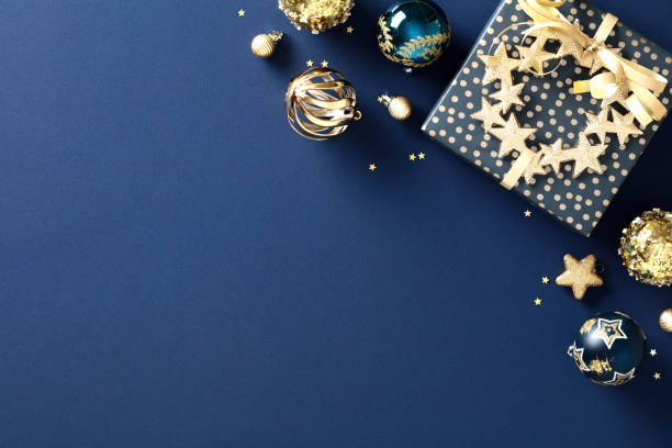 istock Christmas gift with luxury gold decorations on dark blue background. Elegant Xmas banner template. Flat lay. Top view. 1828193302
