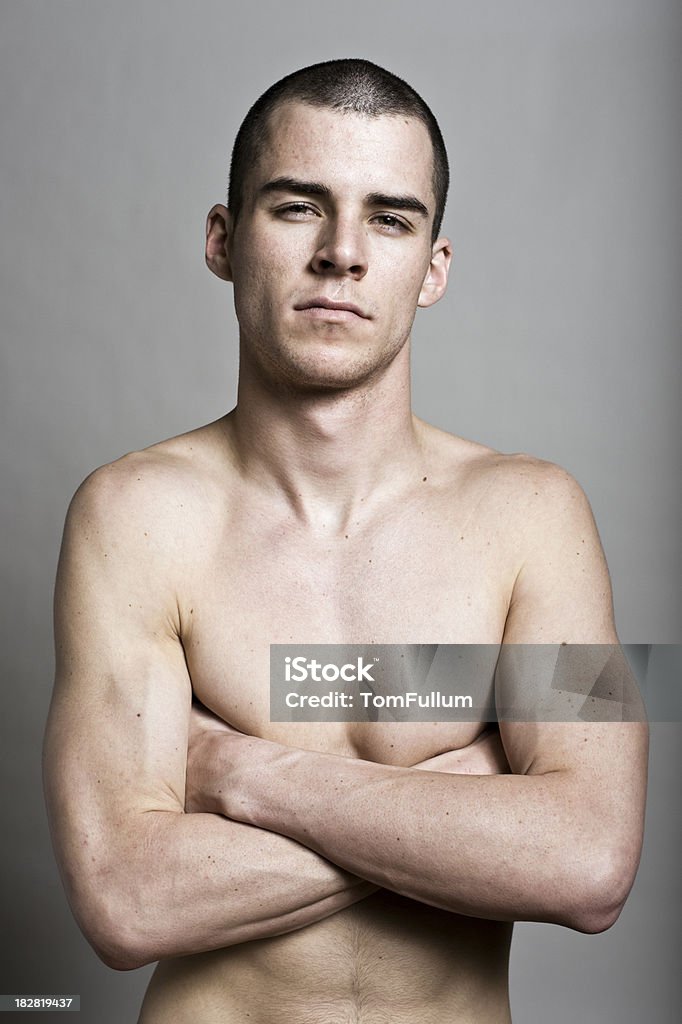 Tough Young Man "Handsome shirtless man with arms crossed and tough, confident expression." Close-up Stock Photo