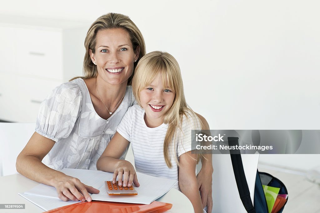 Madre e hija haciendo los deberes juntos - Foto de stock de 30-39 años libre de derechos