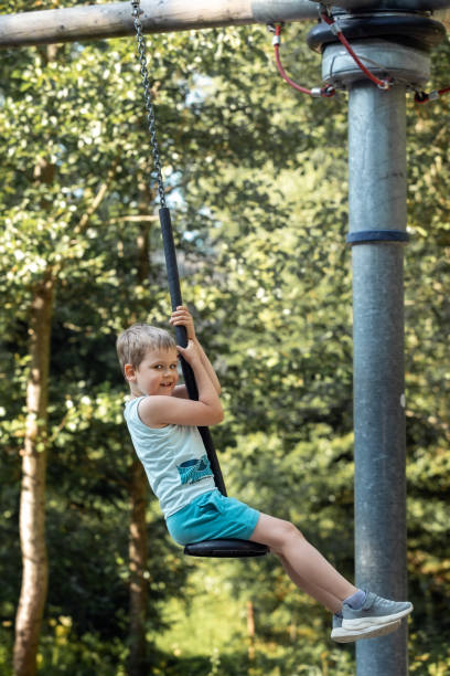 istock Happy boy and tarzan carousel in the forest 1828195548