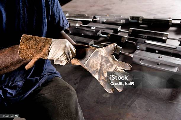 Recortar Afroamericana Trabajador Ajuste Más Fáciles De Guantes Foto de stock y más banco de imágenes de Guantes de protección