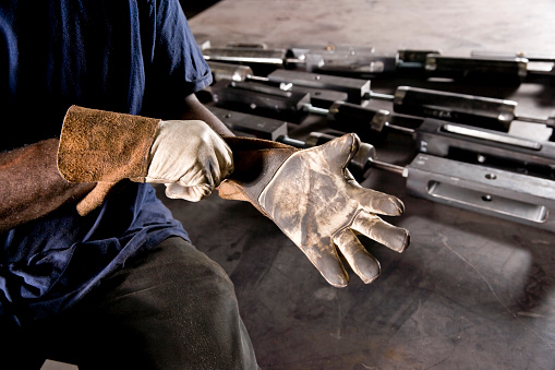 Cropped view of African American worker putting on work gloves