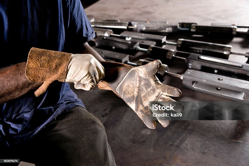 Przycięty African American pracownik założeniem rękawic - Zbiór zdjęć royalty-free (Rękawica ochronna)
