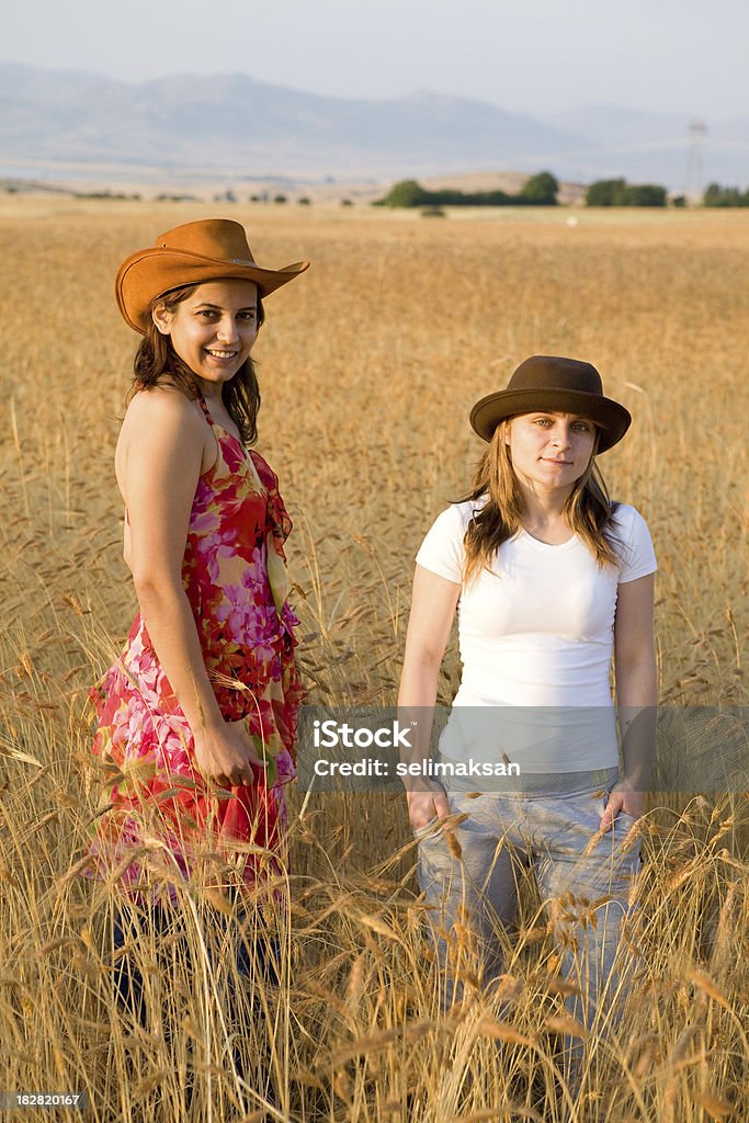 Two women in golden wheat field 20-24 Years Stock Photo