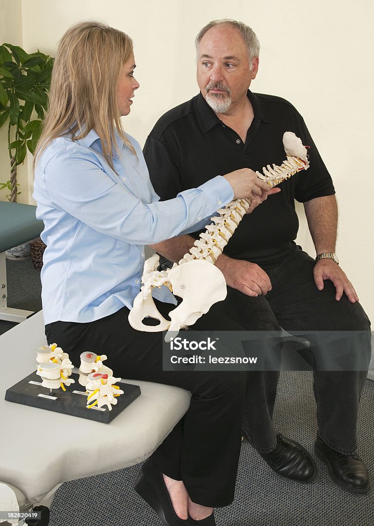 Quiroprático explica a coluna vertebral para o paciente - Royalty-free Adulto Foto de stock