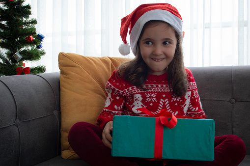 Little girl smiling, opening christmas gifts
