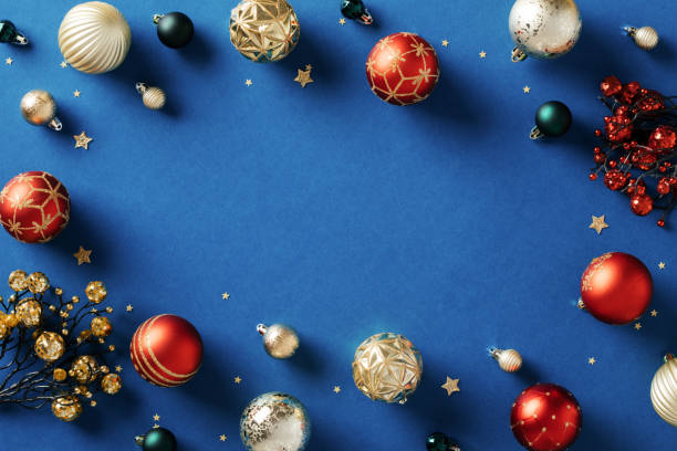 istock Christmas frame. Greeting card template with red and gold balls, berry branches, decorations on dark blue background. 1828209568