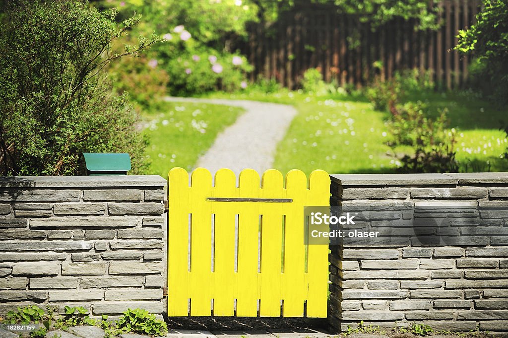 Compuerta amarillo, pared de piedra y jardín - Foto de stock de Abstracto libre de derechos