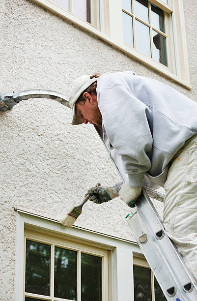 istock House Painter Painting Window Frame and Trim on Ladder 182822917