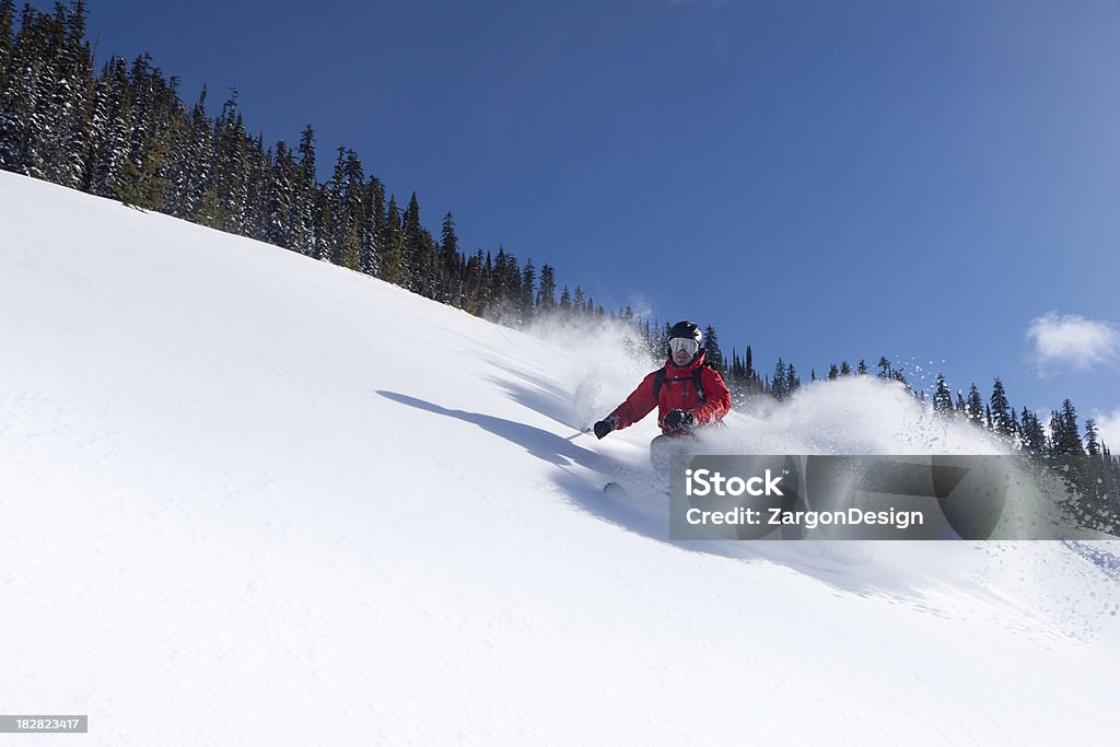 powder skiing Shot in the Kootaney region of British Columbia On a sunny day. Skier makes large powder turn on open slope.Focus is centered on the skier.This photo was shot with a 1ds markIII and 24-70mm L lens.This image was processed from raw format. British Columbia Stock Photo