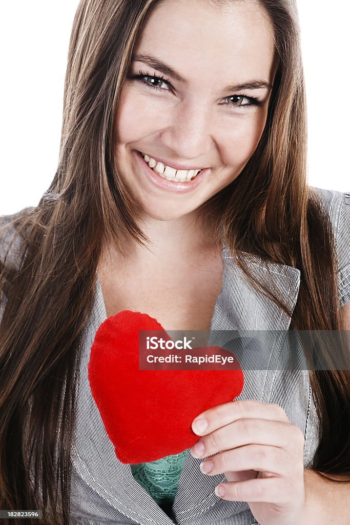 Attractive woman smilingly offers you plush red Valentine heart This pretty young woman is holding out a red velvet Valentine heart  as she smiles flirtatiously at the camera. Shot with Canon EOS 1Ds Mark III. 20-29 Years Stock Photo