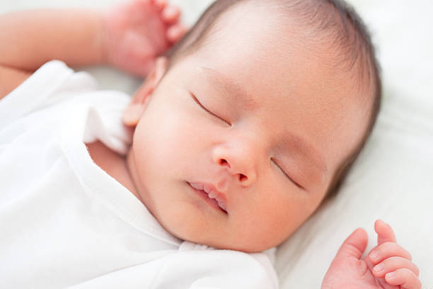 Sleeping newborn baby in white stock photo