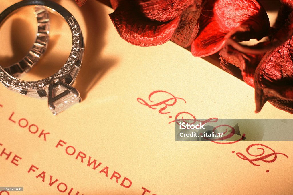 Engagement Ring on Wedding Invitation A wedding invitation surrounded by rose petals. RSVP Stock Photo