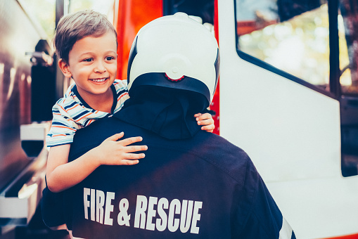 Firefighter carrying little boy after successful rescue operation