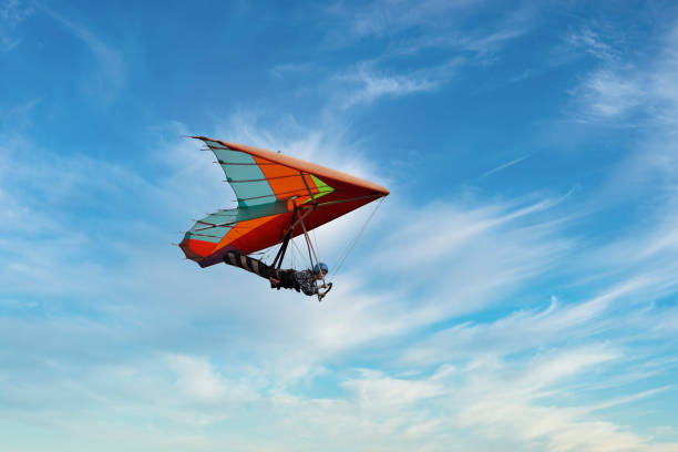 Red hang glider soaring in the blue sky