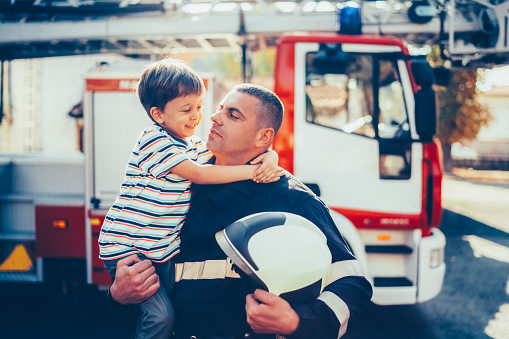 Firefighter with smiling boy after successful rescue operation