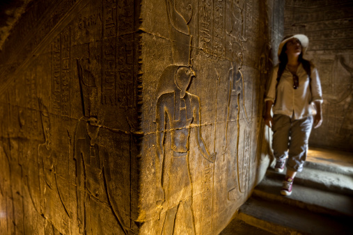 Woman in temple looking at hieroglyphics. Edfu temple.