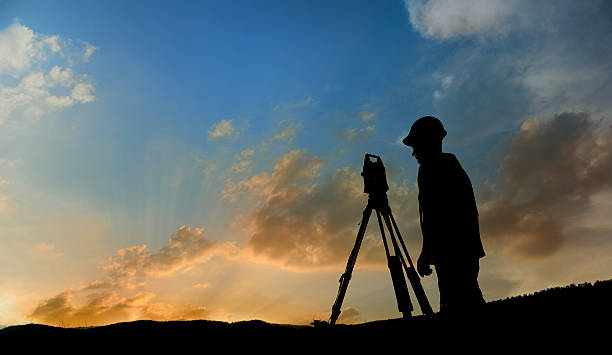 Land-surveyor Land surveyor working with total-station in nature lots of copy space.  surveyor photos stock pictures, royalty-free photos & images
