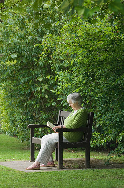 istock Senior woman reading outdoors 182825329