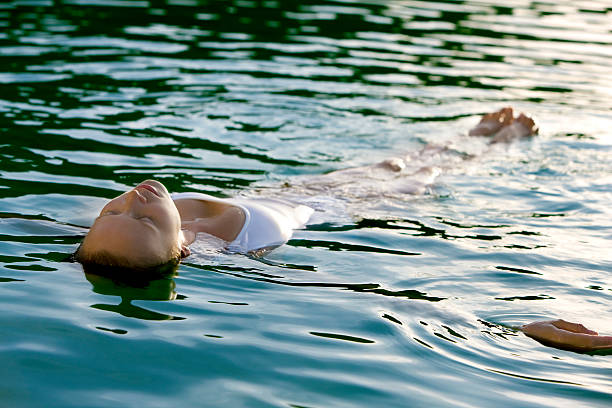 istock woman floating on the water 182825868