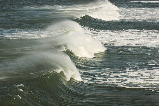 Ocean Wave Surf Spray Windblown spray along crests of ocean waves running into shore.  Santa Clara, California, 2009. mavericks california stock pictures, royalty-free photos & images