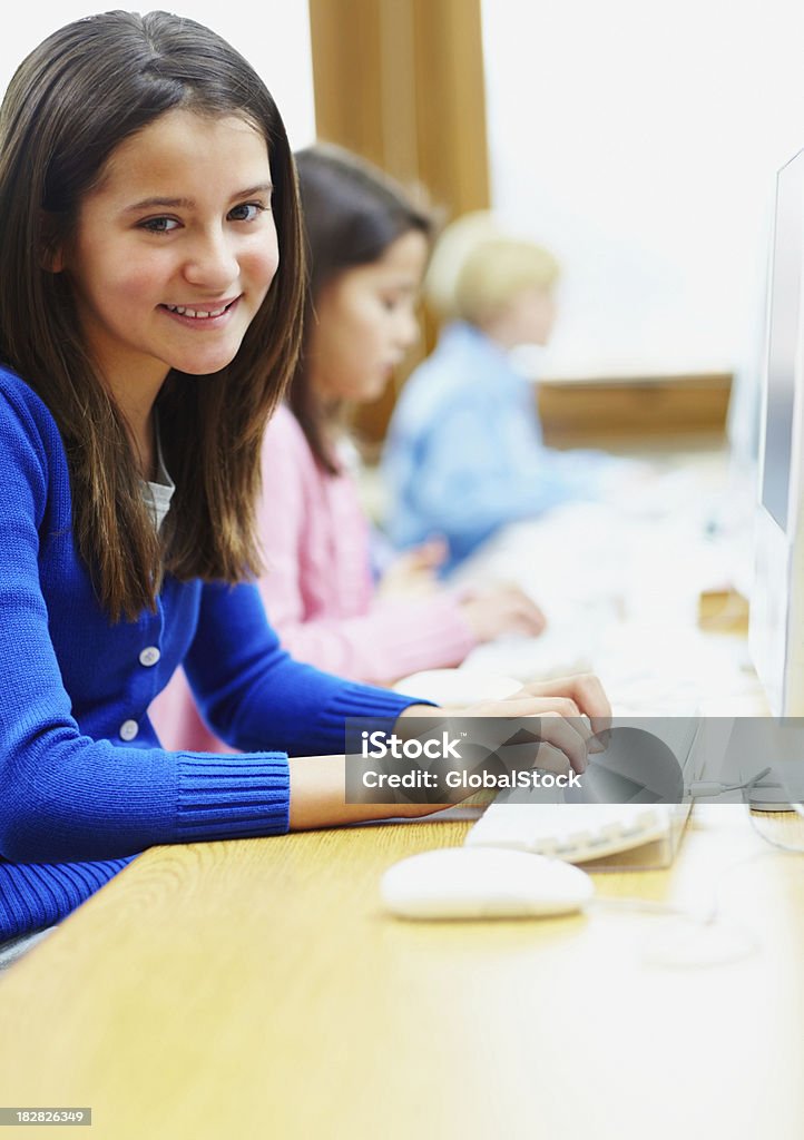 Ritratto di una ragazza sorridente in sala computer - Foto stock royalty-free di 10-11 anni